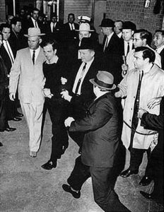 Lee Harvey Oswald being shot by Jack Ruby as Oswald is being moved by police